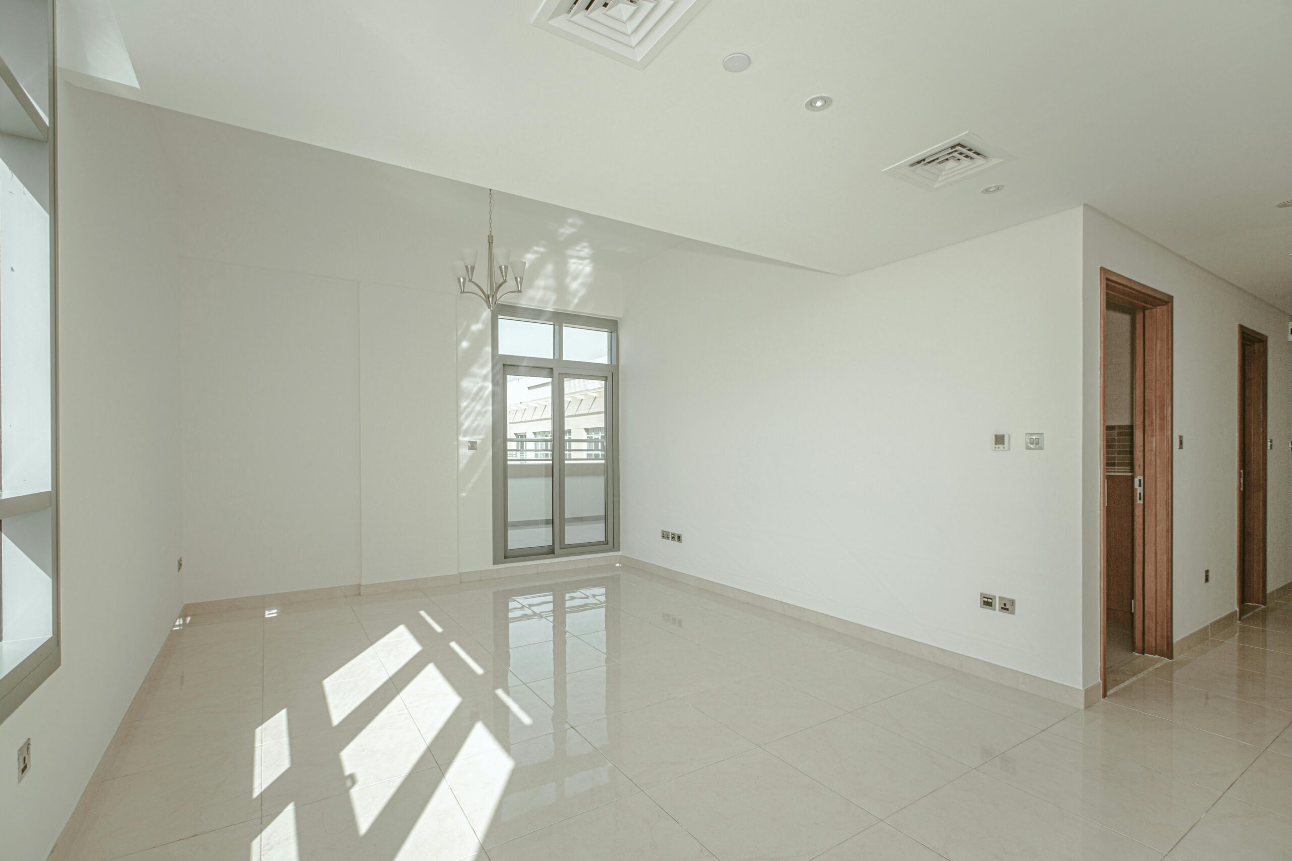 Bright and spacious white room interior with natural light and minimalist design, ideal for real estate presentations.